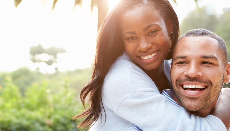 smiling woman looking at camera and hugging fiance