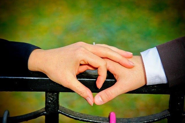 couple holding hands in heart shape