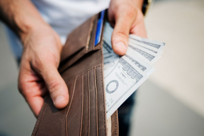 person taking money out of a wallet