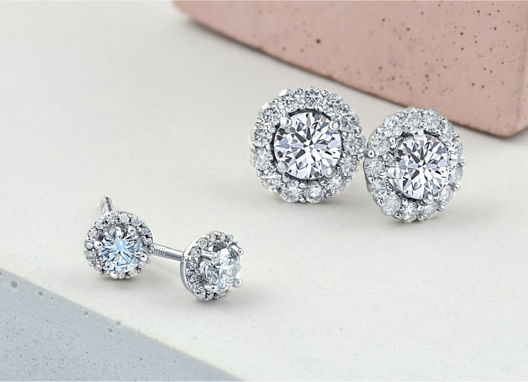 two sets of halo diamond earrings