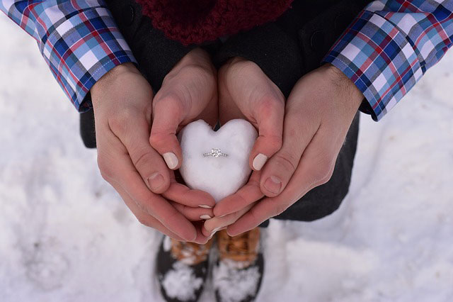 couple holding an engagement ring