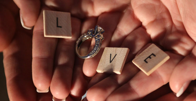 hands holding letter tiles spelling 