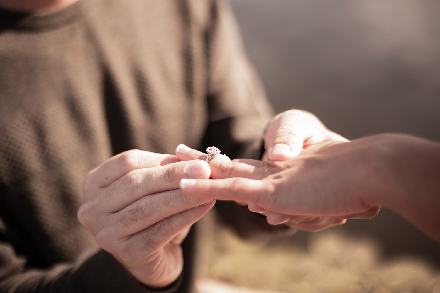 man putting an engagement ring on a woman’s finger