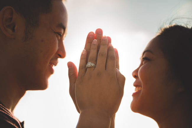 man and woman facing each other with hands pressed together to show wedding ring