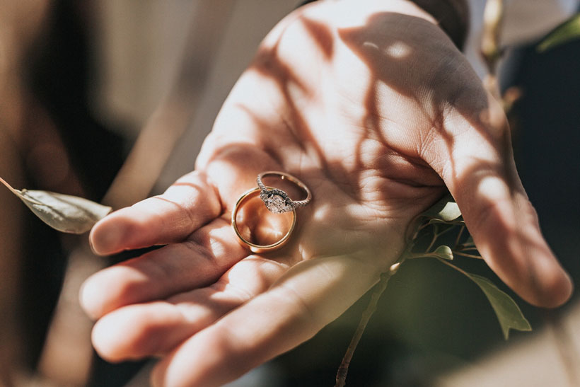 person holding a man and woman’s wedding rings