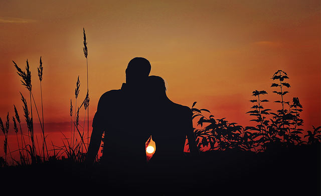 couple sitting together at sunset