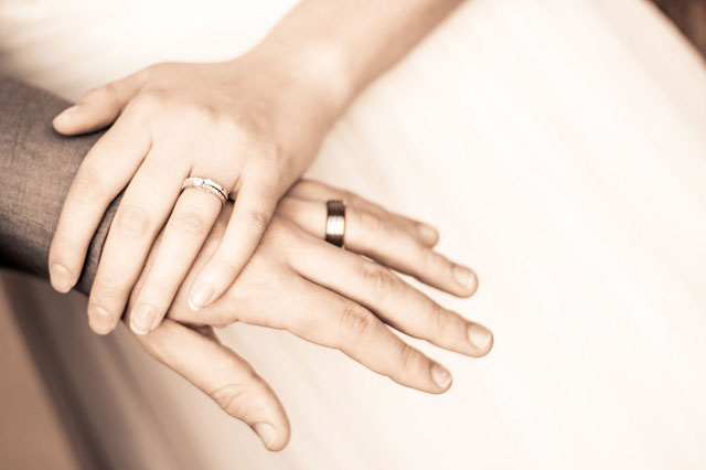couple with rings holding hands